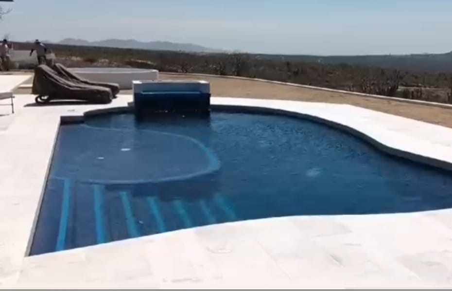 Alberca terminada con borde curvo y paisaje abierto